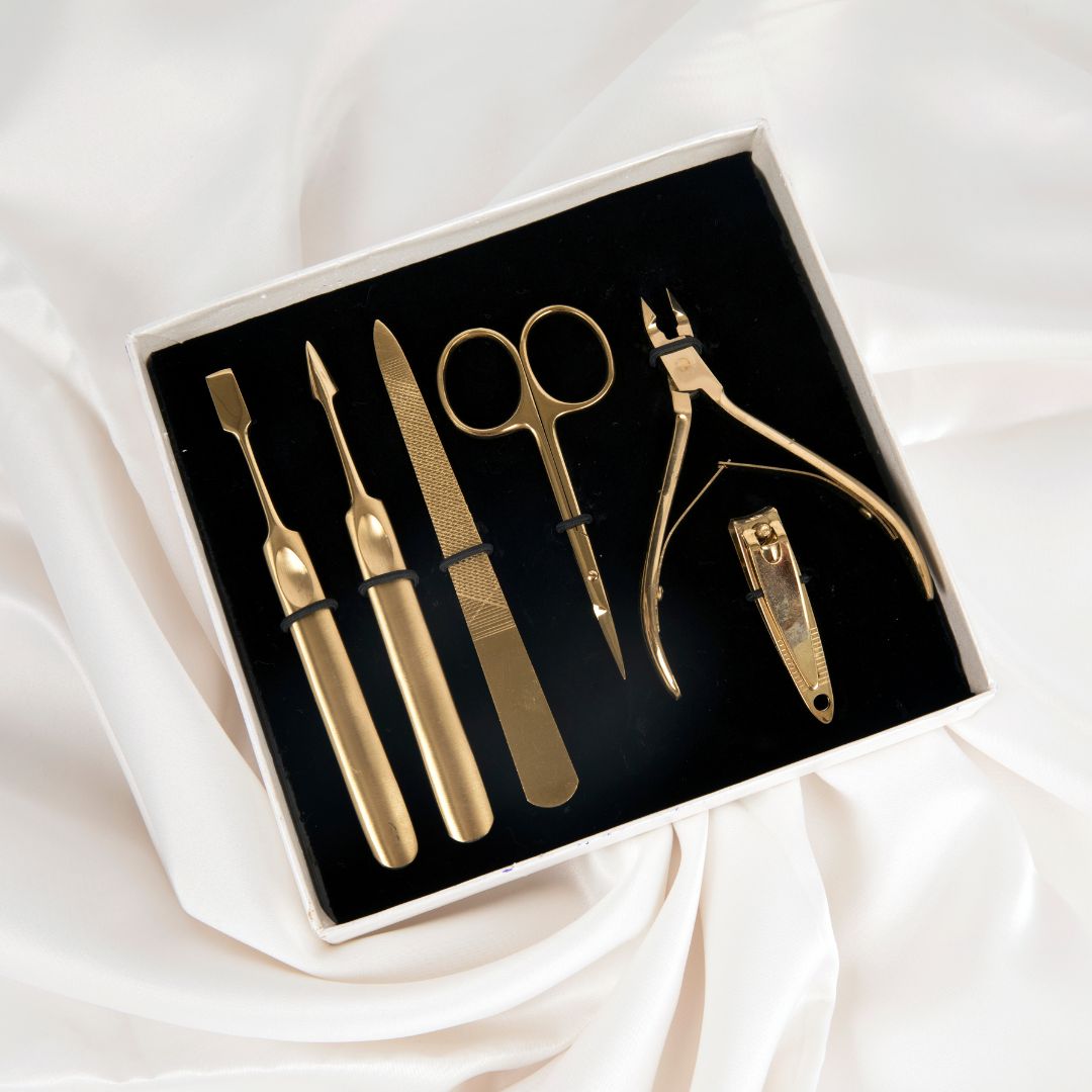 professional manicure tools. on a white background, a six piece gold manicure set is laid out.