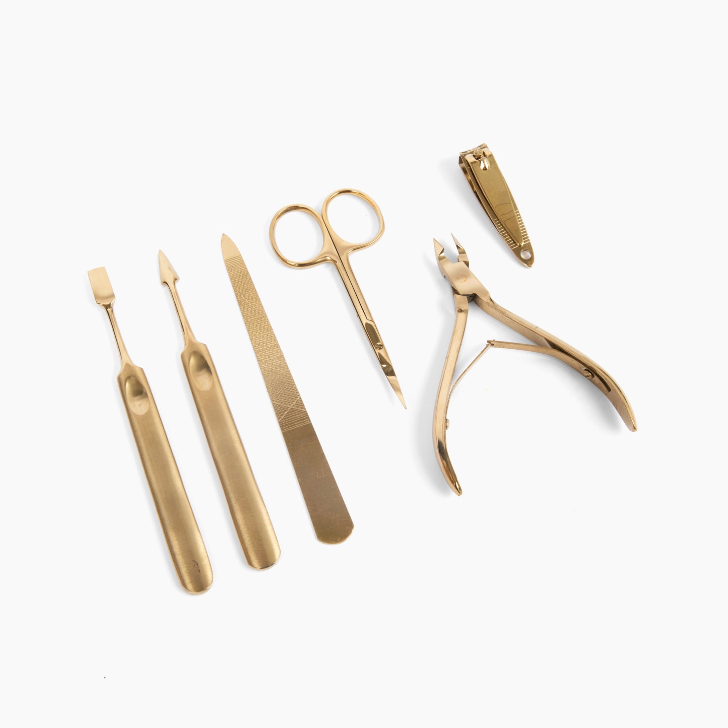 manicure tools. on a white background, a six piece gold manicure set is laid out.