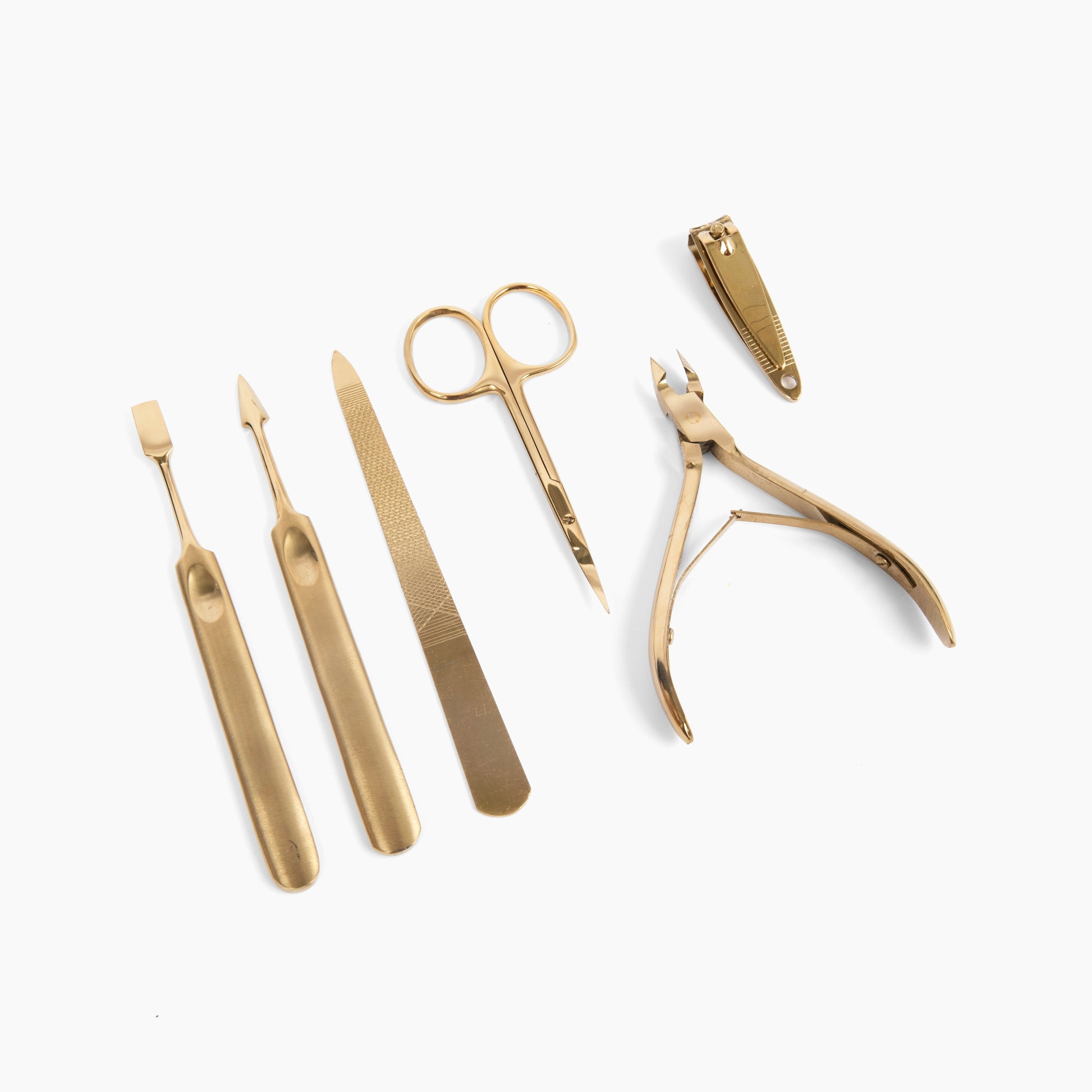 manicure tools. on a white background, a six piece gold manicure set is laid out.
